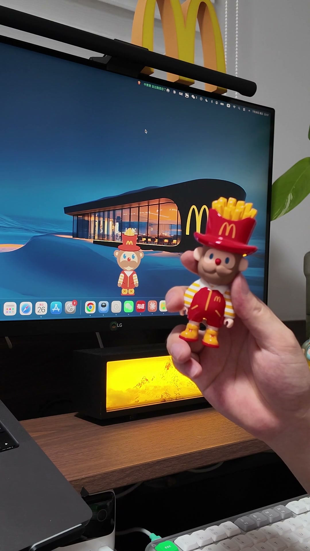 真实工作桌上，薯条先生玩偶和 Mac 屏幕里的 McPet 桌面宠物同框